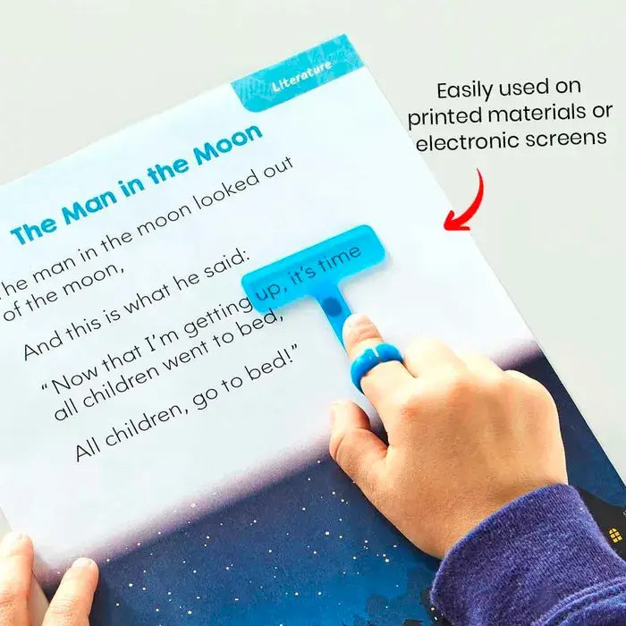 A child's hand wears the blue ring attached to the blue wand, and is highlighting text from a children's book.