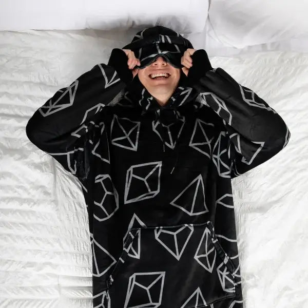 Someone lying in bed pulls the eye mask to the Dice Hideout Hoodie down over their eyes.