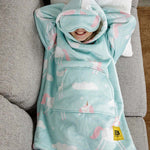 A child lays on a couch with their arms behind their head, cozy in their Unicorn Kids Hideout Hoodie.