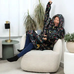 Someone wearing the Player 1 Hideout Hoodie cheers while looking at a tv screen off camera.