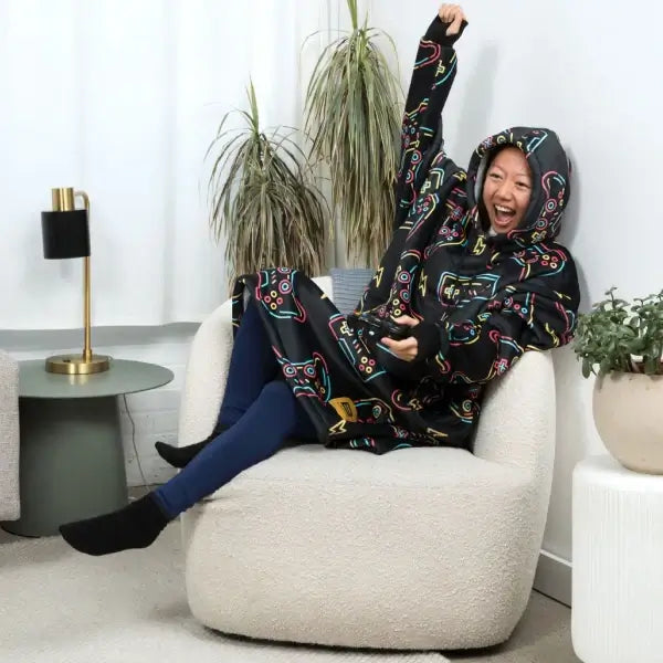 Someone wearing the Player 1 Hideout Hoodie cheers while looking at a tv screen off camera.