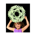 A child smiles and holds the Moon Glow Original Hoberman Sphere over their head.