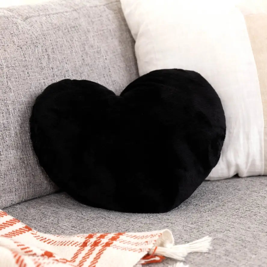 The black Heart to Hug 5 lb Weighted Pillow on a couch.