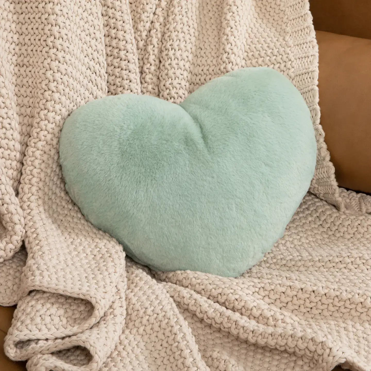 The Sea Glass Heart to Hug Weighted Pillow - 5 lb on a beige blanket.