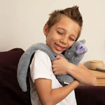 A young boy squeezes Berkeley the Bat with his eyes closed.