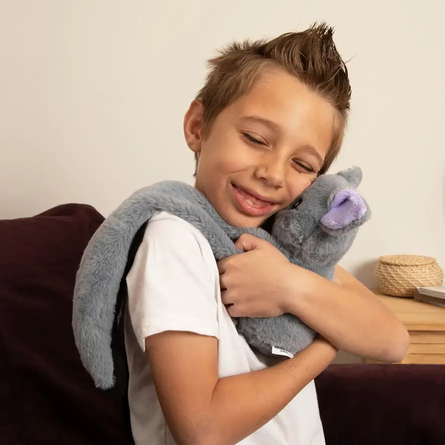 A young boy squeezes Berkeley the Bat with his eyes closed.