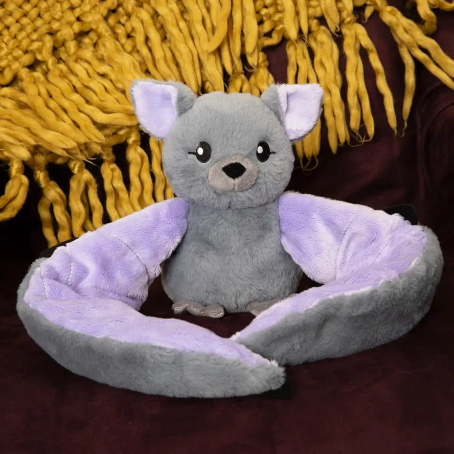 Berkeley the Bat sits poised in front of a yellow rug.