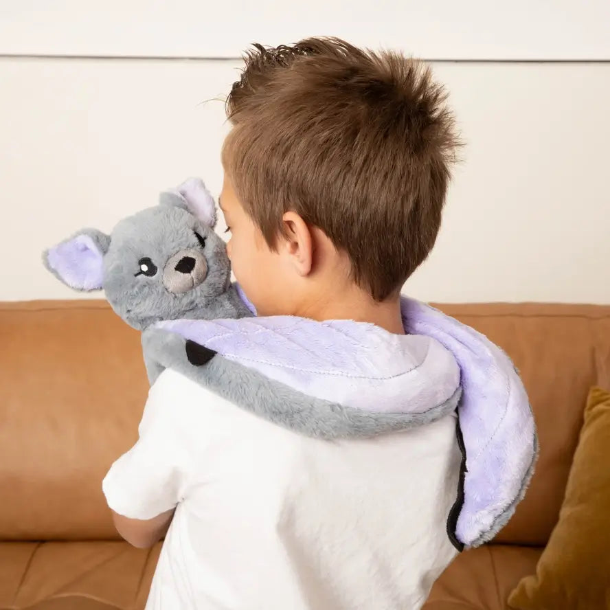 A young child holds Berkeley the Bat from behind.