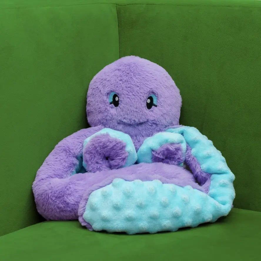 Indigo the Octopus on a green plush seat.