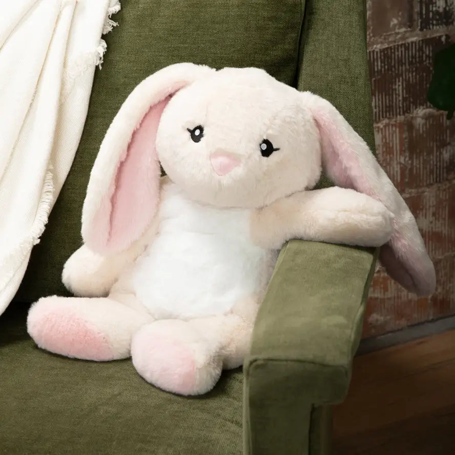 Iggy the Bunny is sitting on a couch with one arm draped over the couch arm.