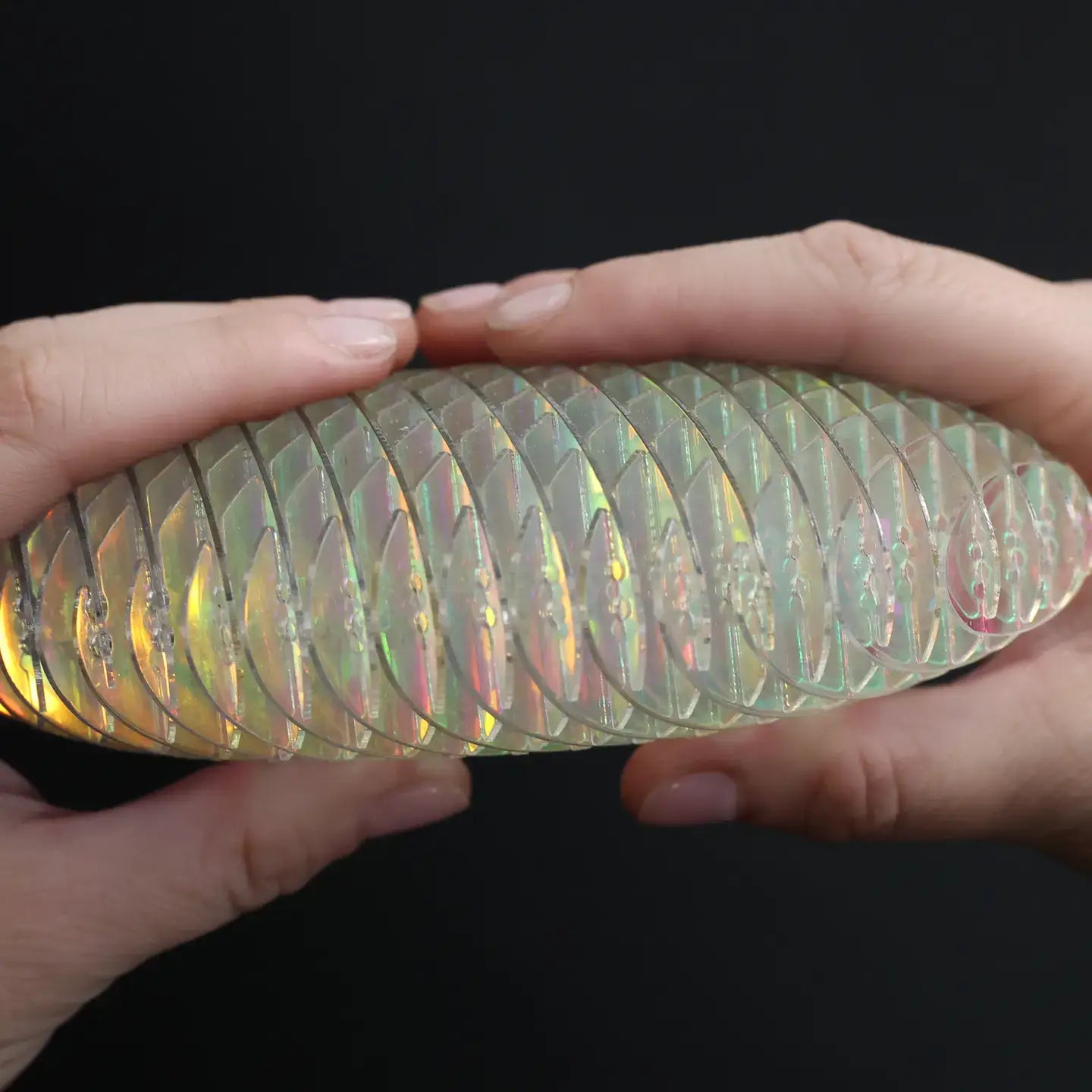 Two hands hold the Morf Fidget Worm 8" Unicorn like a burger.