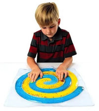 A child with light skin tone and short blonde hair is moving both of the marbles through the Spiral Gel Maze.