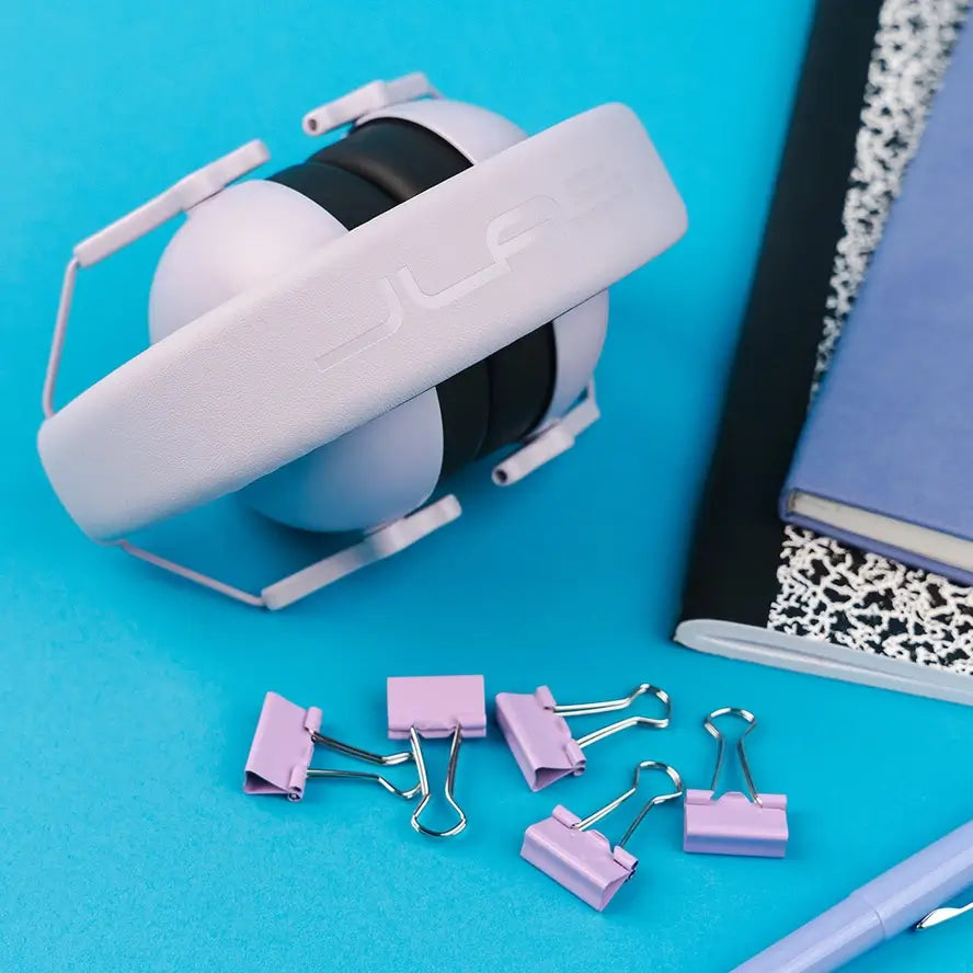 A stylized photo of he Jlab Jbuddies Protect Kids Hearing Protect Earmuffs in Lilac. 