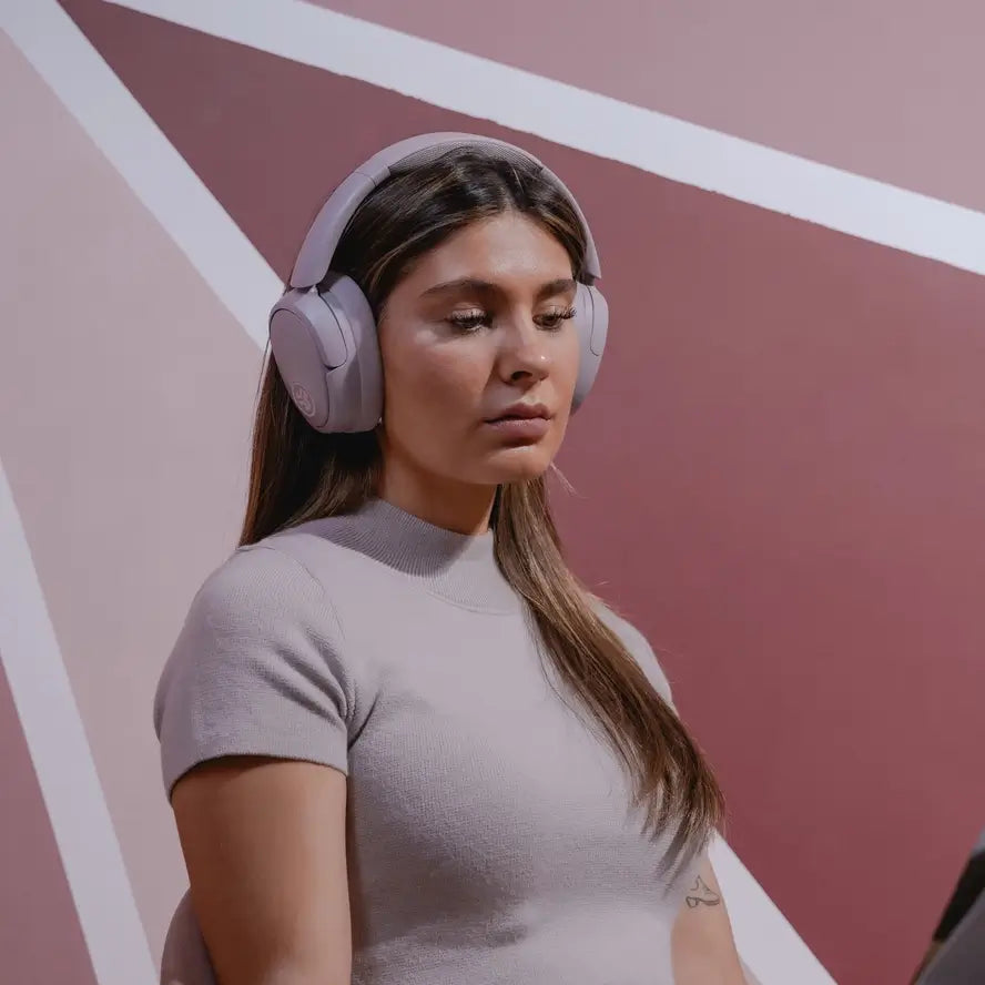 A person is modeling the JLAB Jbuds Active Noise Cancelling Headphones.