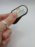 A hand holds the Spiky Silent Fidget Slider, Sensory Tool House Edition.