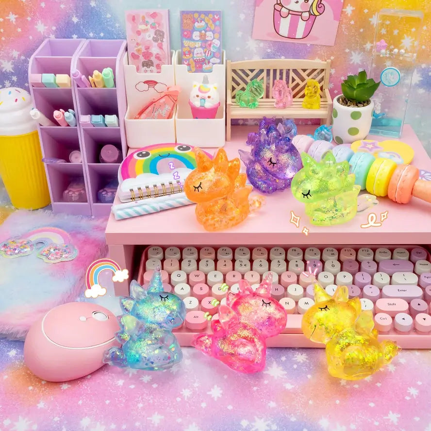 The different color varieties of the Gummy Unicorn Friends lay on a colorful desktop scene.