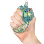 A hand squishes the blue Gummy Unicorn Friend.