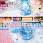 An open jar of the Polar Bear Plunge Clear Slime sits staged next to a multicolor keyboard and colorful office supplies.