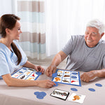 A senior moves a blocking piece over a game piece in a game of Animal Bingo with a nurse.