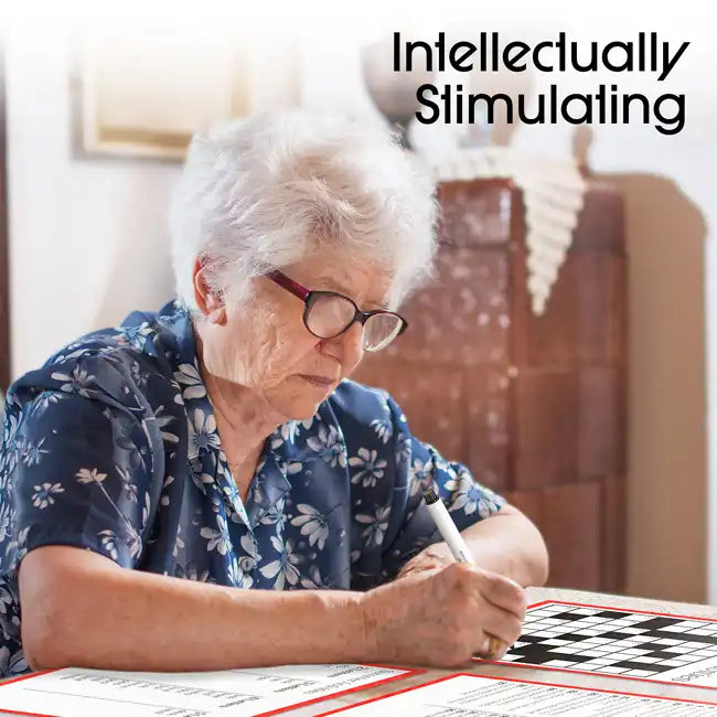 A senior sits at a table while working at a crossword puzzle.