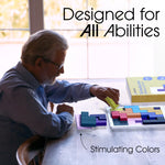 A man sits at a table and places a tile on the Keeping Busy Tile Matching Game for Seniors.