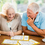 Two seniors laugh together while working on the Keeping Busy Word Search Puzzles for Seniors.