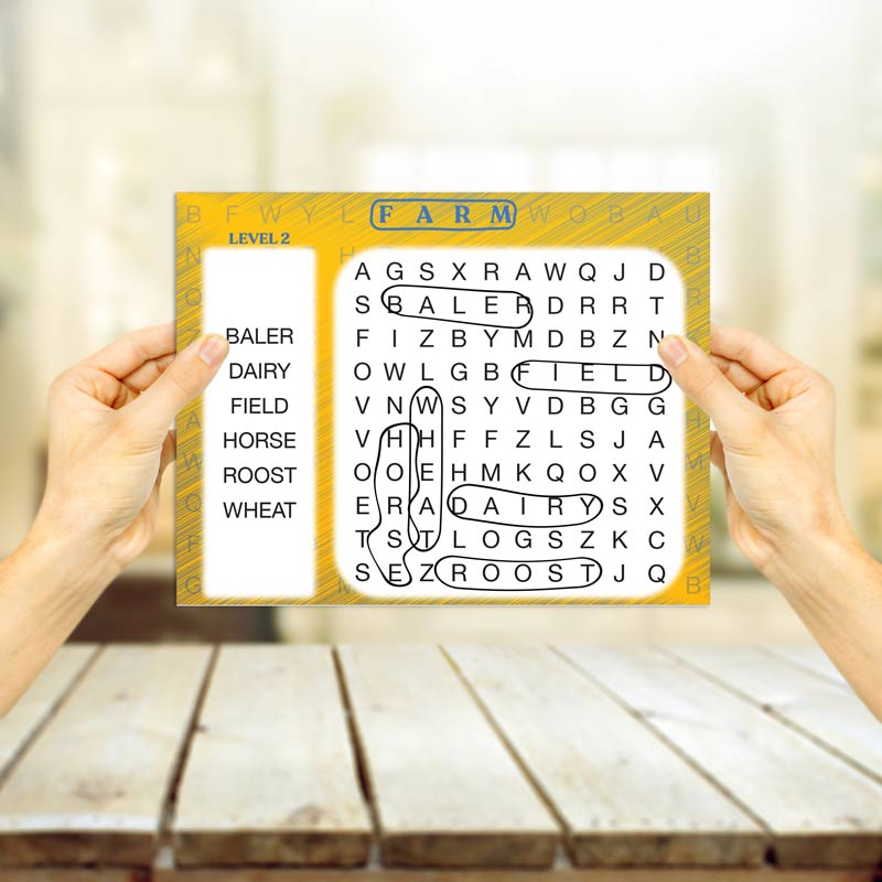 Two hands hold up a Word Search Puzzle for Seniors.