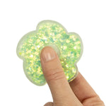 A hand holds the green Glitter Fidget Spinner.