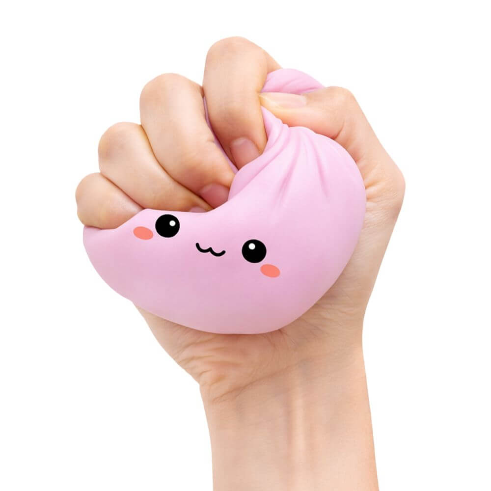 The light pink  Lucky Bao Mystery Squishy Dumpling being squeezed by a hand.