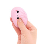 A hand squeezes the light pink Mini Lucky Bao Mystery Squishy Dumpling.