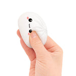 A hand squeezes the white Mini Lucky Bao Mystery Squishy Dumpling.