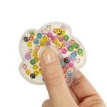A hand holds the Smiley Face Fidget Spinner.