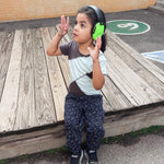 A child with noise reducing earmuffs also wears the Grey-Mint Kids Compression Lined Sensory T-shirt.