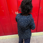 A child stands with their back to the camera in their Constellation Print Kids QuietSense™ Sound Reducing Sensory Hoodie.