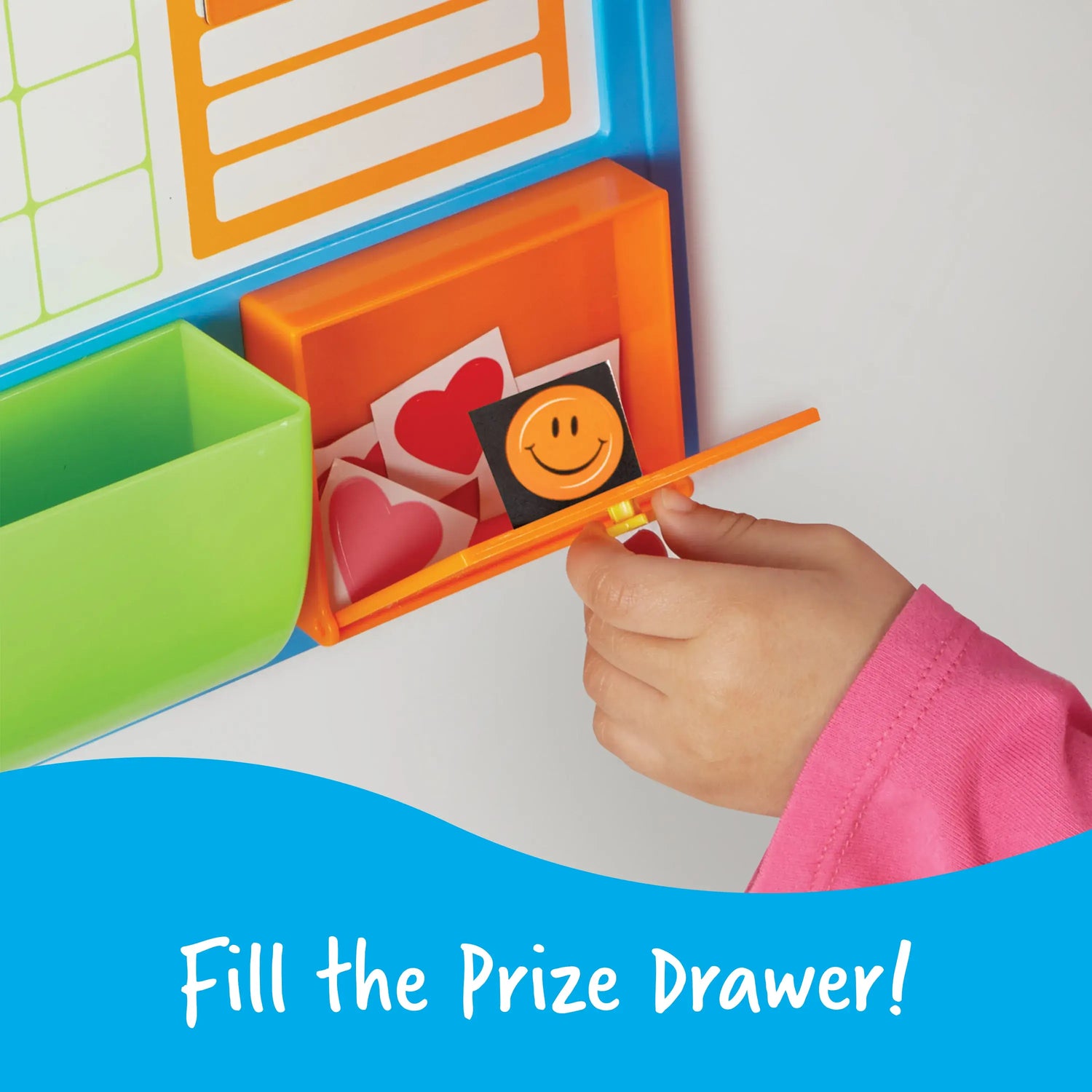 A child pulls a sticker out of an orange storage container on the Good Job Reward Chart.