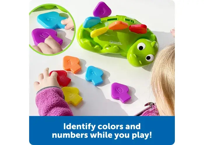 A child lines up the color and number coordinated scales of Steggy the Fine Motor Dino.
