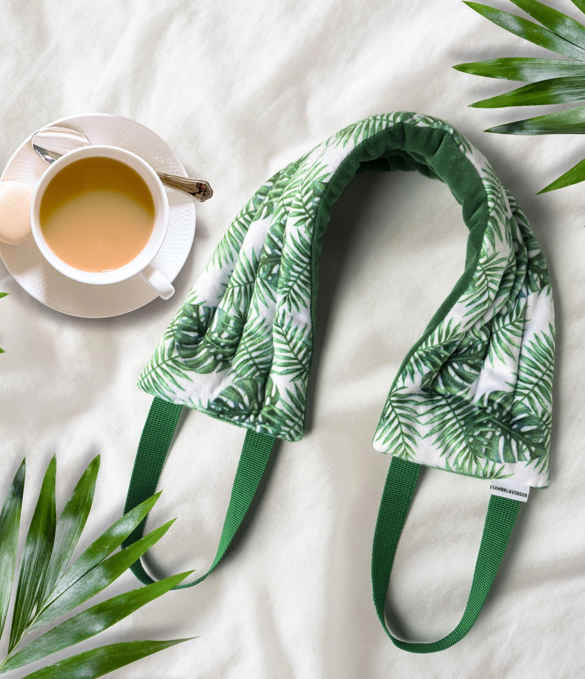 The Green Leaf Lemon Lavender Hot Stuff Heated Neck Wrap next to a cup of tea.