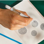 A hand doodles using the Lifelines Spiced Chai Latte Essential Oil Pen Diffuser  on an embossed page.