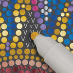A gold marker fills in the letter V on a FlowArt Dot-by-Marker scene.