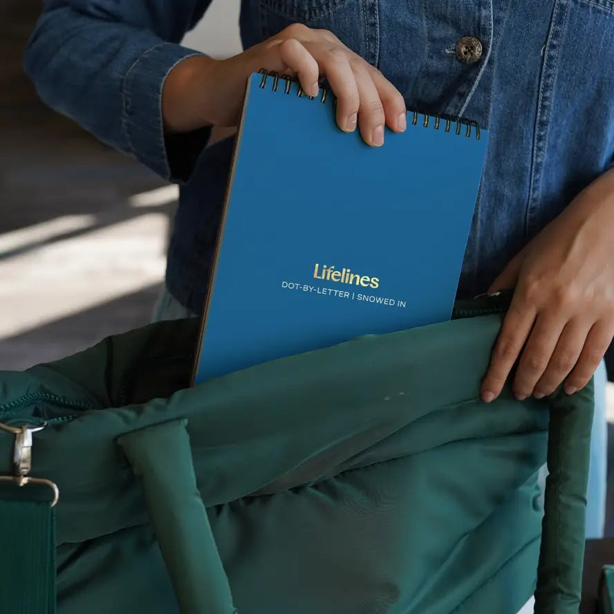 A hand pushes a Lifelines notepad into a bag.