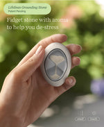 A hand holds the Grounding Stone in the Sensory Essentials Travel Set.