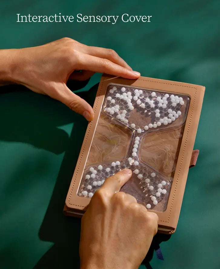 A hand moves the beads around on the cover of the "Take Your Time" Tactile Sensory Journal.