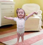 A child wears the Light Pink Kozie Medical and G-Tube One-Piece Bodysuit - The Susie.