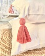 A close-up look at the pink tassels on the pillow case.