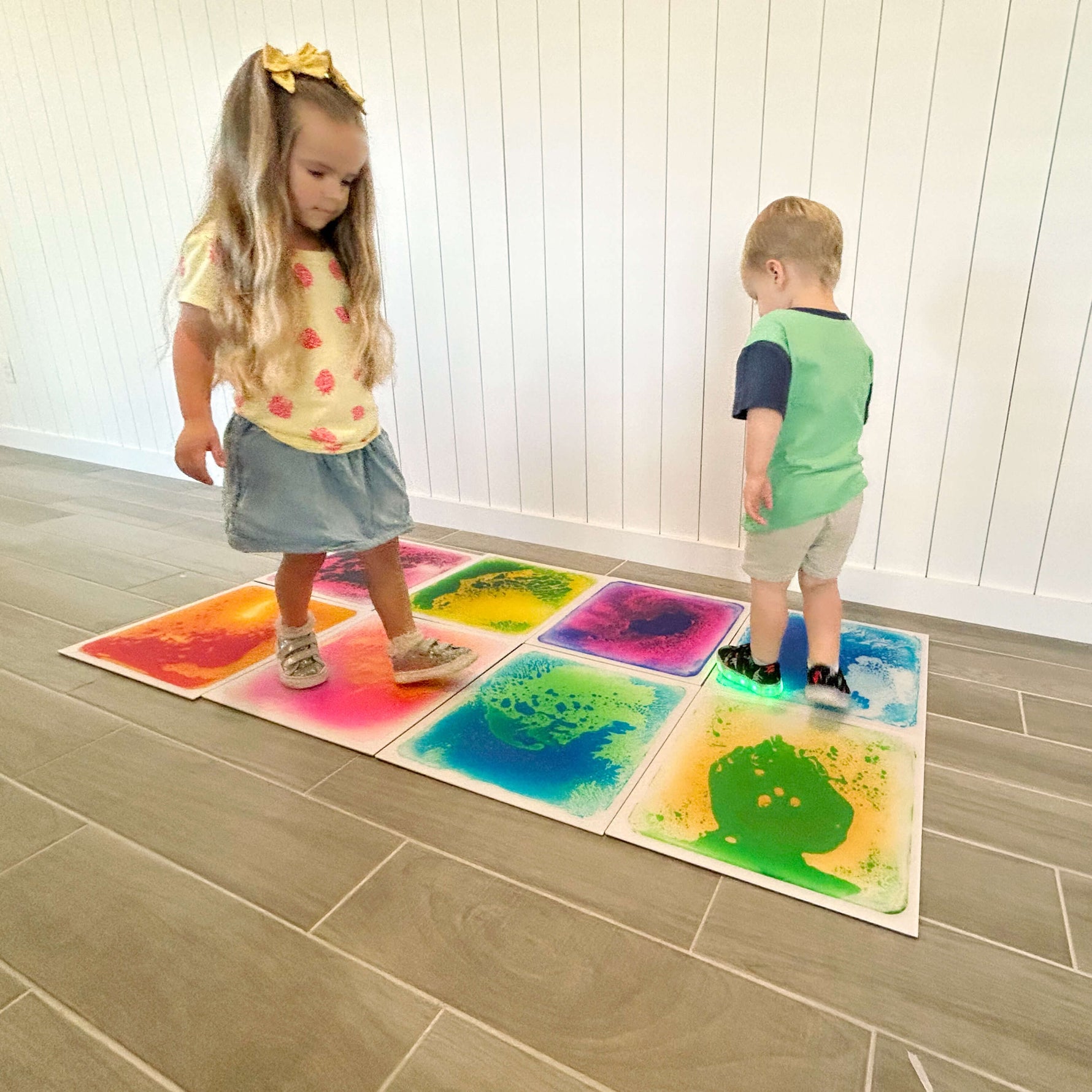 Two children play on the Liquid Floor Tiles.