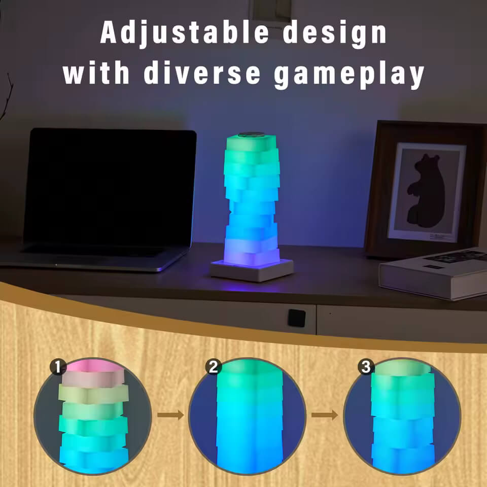 The Magic LED Cube Desk Lamp sits in a purple to green ombre on a counter top next to a laptop and a piece of art in a frame.