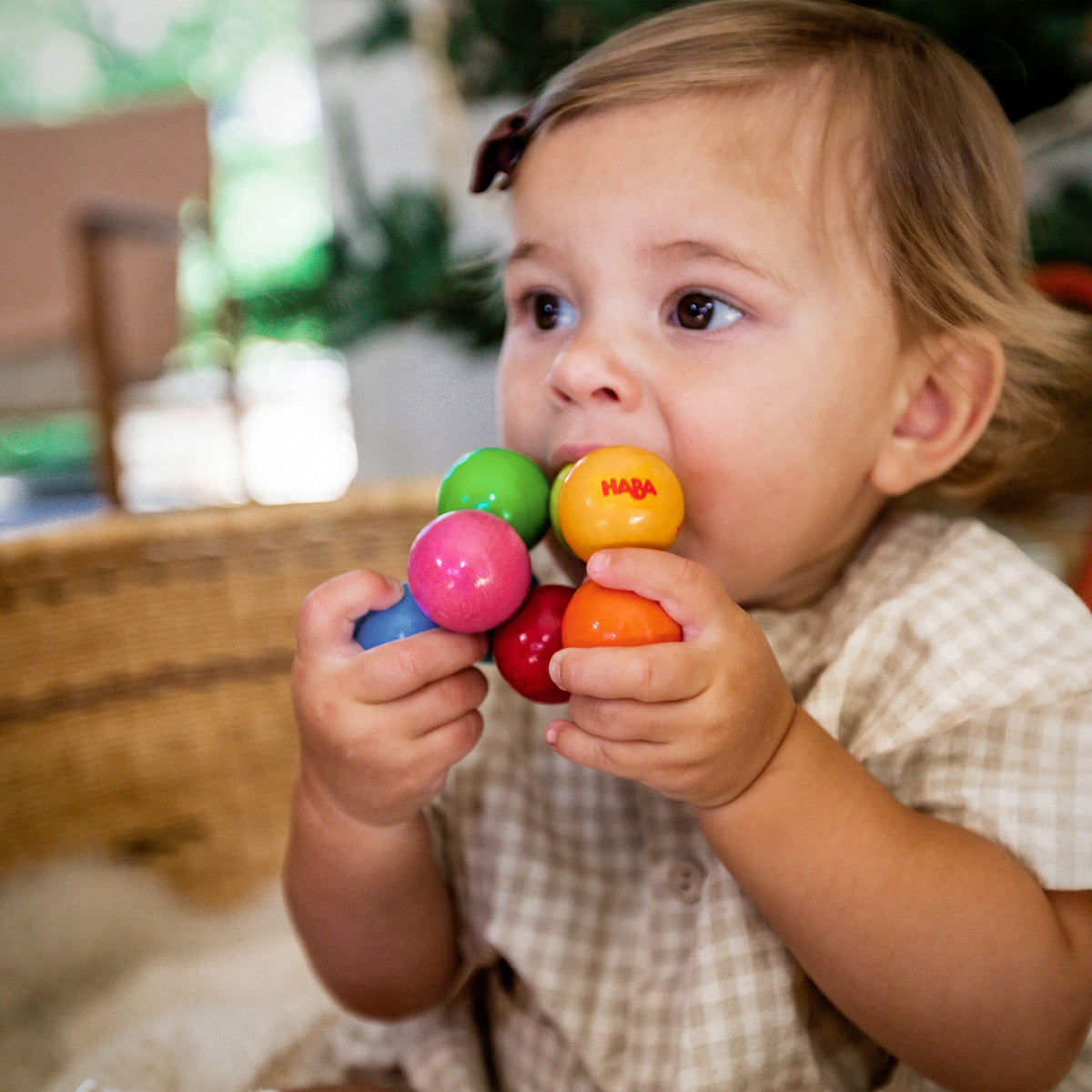A toddler chews on the Magica Grasping and Teething Toy by HABA.