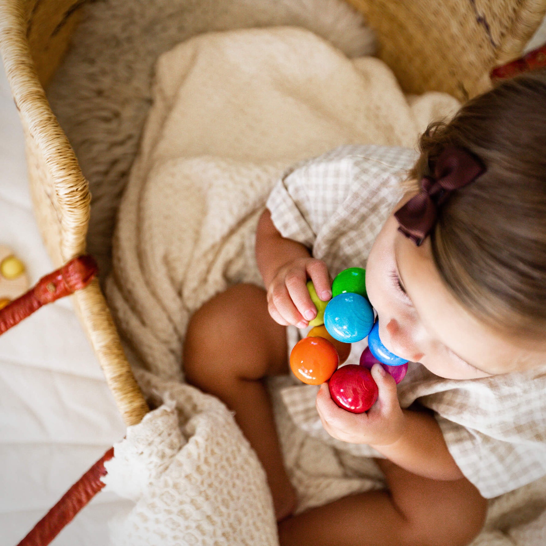 A top down look at a child teething on the Magica Grasping and Teething Toy by HABA.