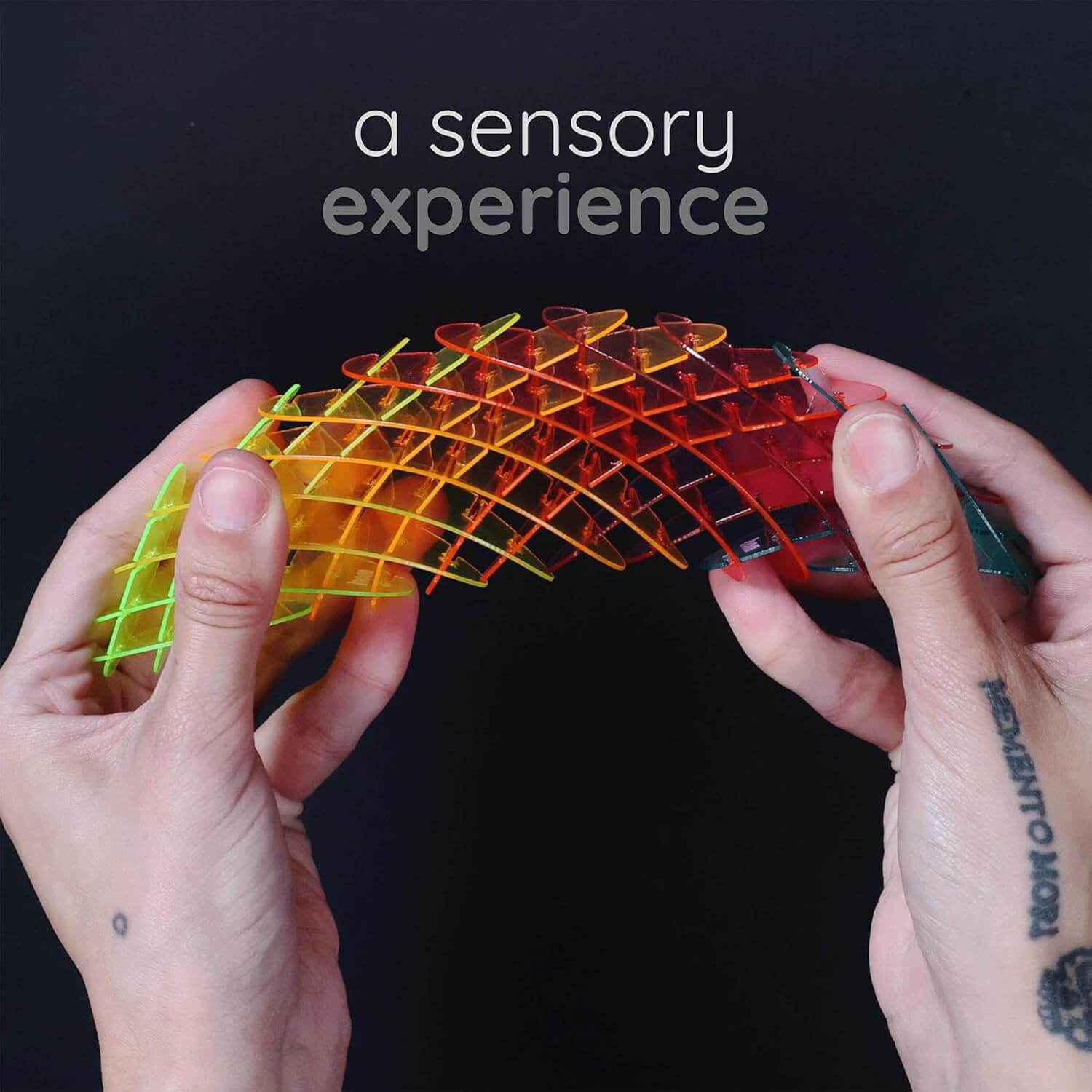 Two hands pull the Rainbow Morf Fidget Worm in opposite directions.