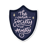 A sticker the shape of a shield reads: The Secret Society of Anxiety.